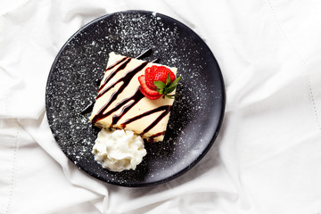 American cheesecake with strawberry and whipped cream.Classic New York cheesecake on a plate. top view. Copy space for your text 