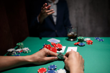 professional poker game. Green poker table with two games. poker player makes a bet by throwing chips on the table