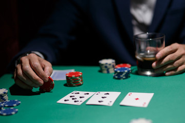 Fototapeta na wymiar professional poker game. Green poker table with two games. poker player makes a bet by throwing chips on the table