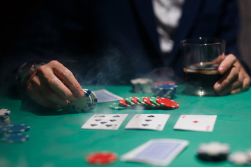professional poker game. Green poker table with two games. poker player makes a bet by throwing chips on the table