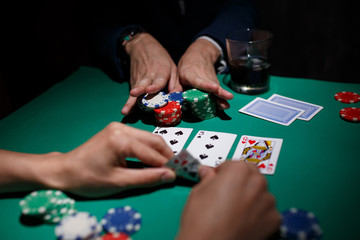 professional poker game. Green poker table with two games. poker player makes a bet by throwing chips on the table