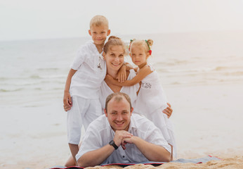 Happy young family on the sunset at the beach.