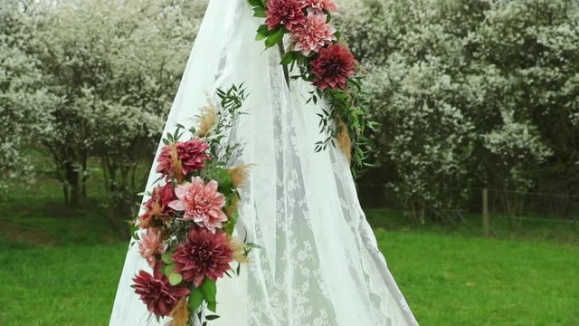 Wedding table and decoration with cake in the middle of a field in the background of flowering trees.