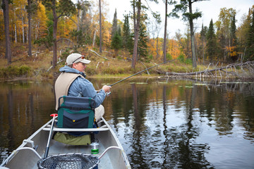 40s caucasian fisherman fishing on small lake in northern Minnesota during fall