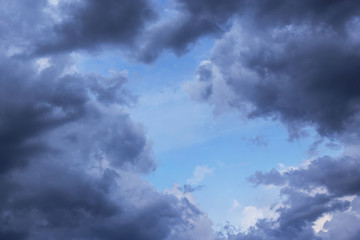 Obraz premium Cumulus scenic storm clouds in the blue sky background. Darkness and light, heaven