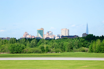view of Saint Petersburg city silhouette from Pulkovo airport with runway and forest on the foreground