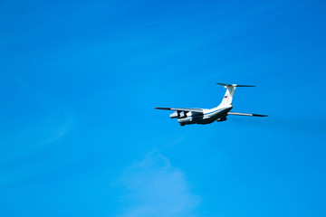 Heavy cargo airplane with four engines after takeoff with summer blue sky on the background