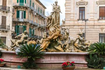 Famous Artemis (Diana) Fountain on Archimedes Square on the Ortygia isle - old town of Syracuse on Sicily island, Italy - obrazy, fototapety, plakaty