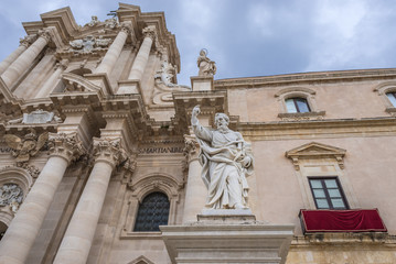 Fototapeta na wymiar Saint Paul statue in front of Syracuse Cathedral and Archbishop's Palace (right) on Ortygia isle, Syracuse city, Sicily Island in Italy