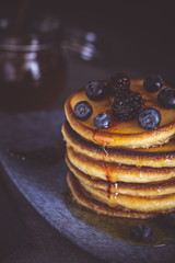 Pancakes with Fresh Berries and Maple Syrup on Dark Background. Classic American Homemade Breakfast.