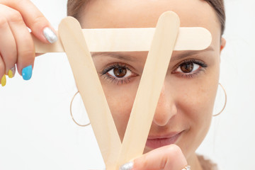 Depilation master girl Looks through wooden sticks for depilation. nurse