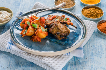 Spiced lamb cutlets with Bombay aloo with minted yogurt.