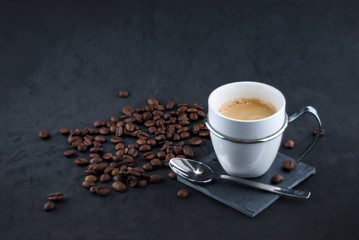 cup of coffee with coffee beans on black background