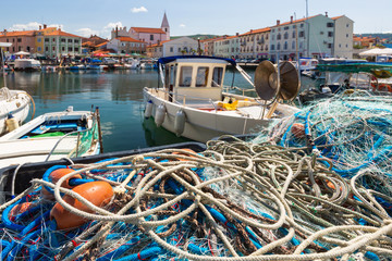 Scenic harbour with boats and brightly coloured houses on the fishing net waterfront in Izola -...