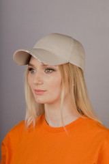 Beautiful girl with natural make-up in a headdress on a gray background.