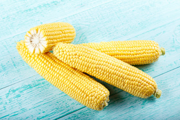 Fresh corn on cobs on rustic wooden table
