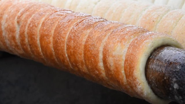 Close up chimney cake baking and rolling