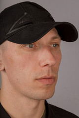 Handsome young man in a headdress on a gray background.