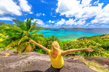 Top view panorama of Praslin, Seychelles. Carefree woman in yellow dress enjoying amazing views of...