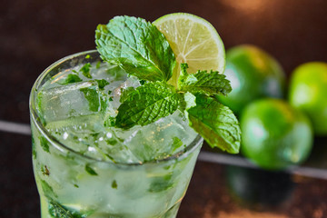 Summer fresh classic mojito with mint and lime garnish on bar top in restaurant 