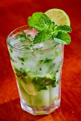 Summer fresh classic mojito with mint and lime garnish on bar top in restaurant 