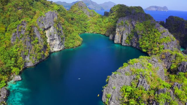 Fly around the rocky mountains with beautiful lagoons and turquoise sea in El Nido, Palawan, Philippines. Aerial view 4K