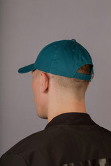 Handsome young man in a headdress on a gray background.