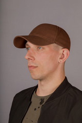 Handsome young man in a headdress on a gray background.