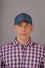 Handsome young man in a headdress on a gray background.