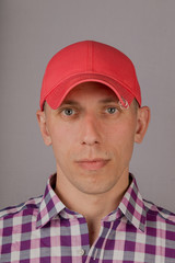 Handsome young man in a headdress on a gray background.