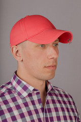 Handsome young man in a headdress on a gray background.