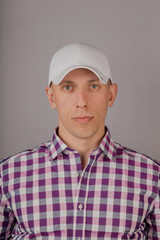 Handsome young man in a headdress on a gray background.