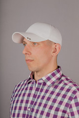 Handsome young man in a headdress on a gray background.