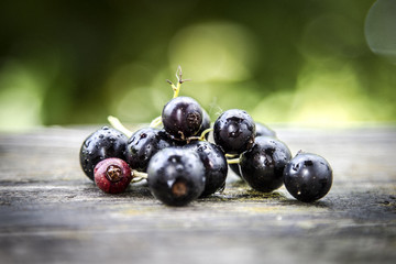 Blackcurrant berries laying on wooden surface