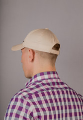 Handsome young man in a headdress on a gray background.