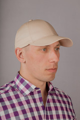 Handsome young man in a headdress on a gray background.