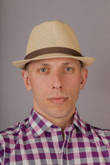 Handsome young man in a headdress on a gray background.