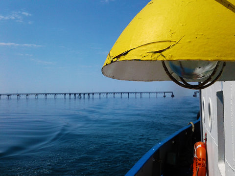white lifebuoy on the blue wall and yellow lamp on ferry