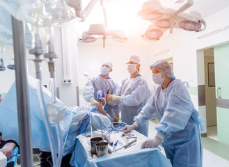 Arthroscope surgery. Orthopedic surgeons in teamwork in the operating room with modern arthroscopic...