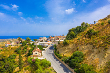 Pissouri. Cyprus. Pissouri village panorama on a sunny day. The road along the mountains leads to...