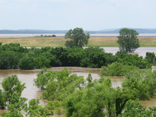 Muddy water covers fields in flood waters along the Arkansas River