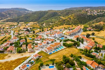 Foto auf Acrylglas Cyprus. Pissouri village in the valley at the foot of the mountains. The streets of the village of Pissouri panorama.  Resort Pissouri Bay. Travelling to Cyprus. Panorama of the village with drone. © Grispb