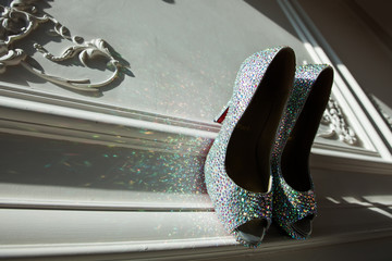 Women's silver-colored heel shoes with multi-color rhinestones and highlights on the carved panel