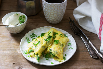 Homemade breakfast of omelet with asparagus and onions and hot coffee. Rustic style.