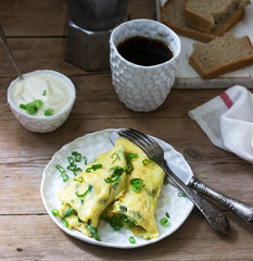 Homemade breakfast of omelet with asparagus and onions and hot coffee. Rustic style.