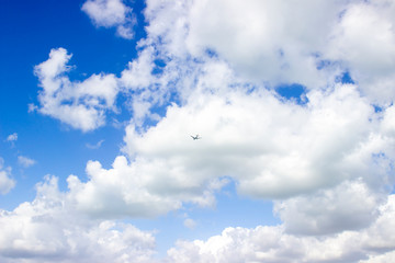 Airplane flying in a blue sky with clouds 