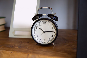 Naklejka premium Vintage alarm clock on weathered wood background