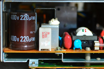 Abstract background of the old circuit board and radio components. Part of old vintage printed circuit board with electronic components. Closeup with shallow DOF
