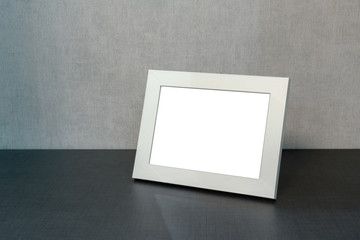 white photo frame horizontally stands on the shelf in the living room, minimalism in the interior...
