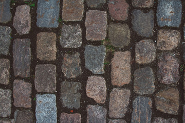 The texture of the old cobblestone and unusual stones. Patterned paving tiles cobblestone road for texture. Top view. Copy space. Can use as banner